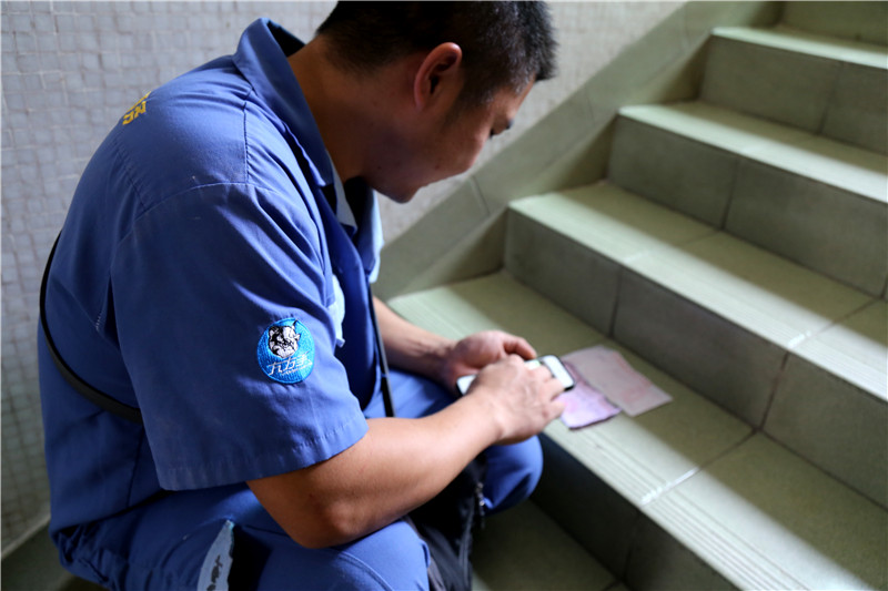 客戶還是沒有到，家具安裝謝師傅蹲在門口等，一邊等一邊處理今天要去的下一家客戶的資料